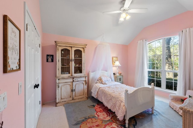 bedroom with a closet, lofted ceiling, light colored carpet, and ceiling fan