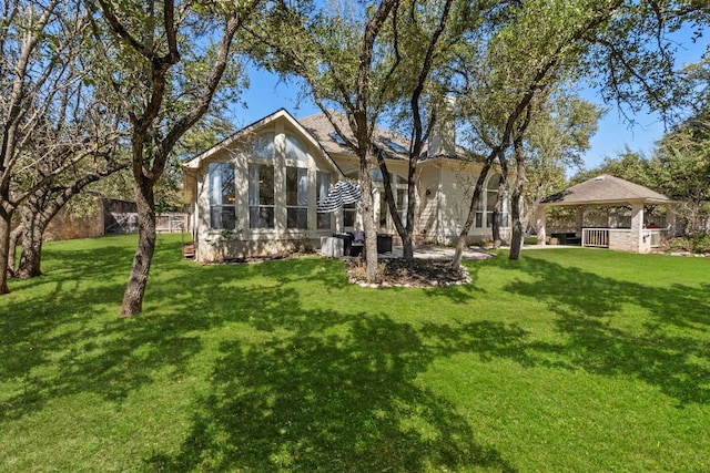 back of house featuring a gazebo, a lawn, and fence