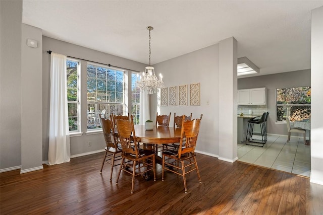 dining area with wood finished floors, baseboards, and a chandelier