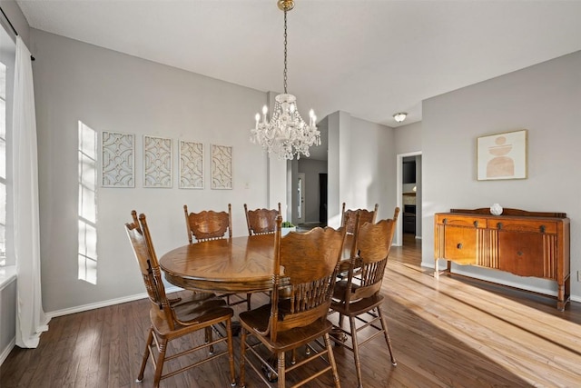 dining area with an inviting chandelier, wood finished floors, and baseboards