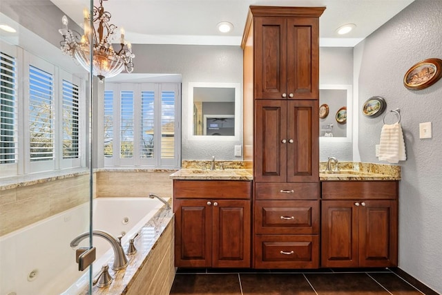 bathroom featuring tile patterned floors, a notable chandelier, a sink, a tub with jets, and double vanity