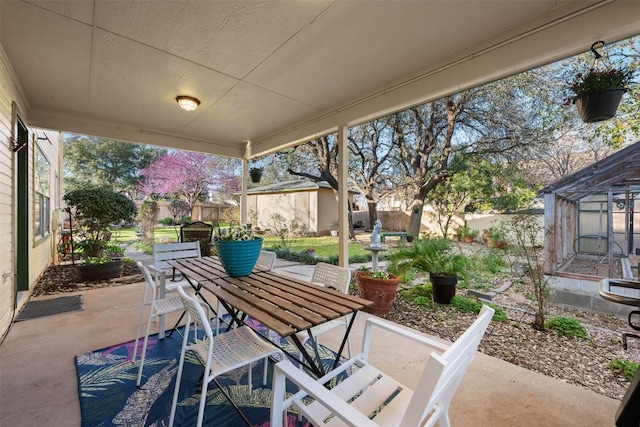 view of patio / terrace with outdoor dining space, an outdoor structure, and a fenced backyard