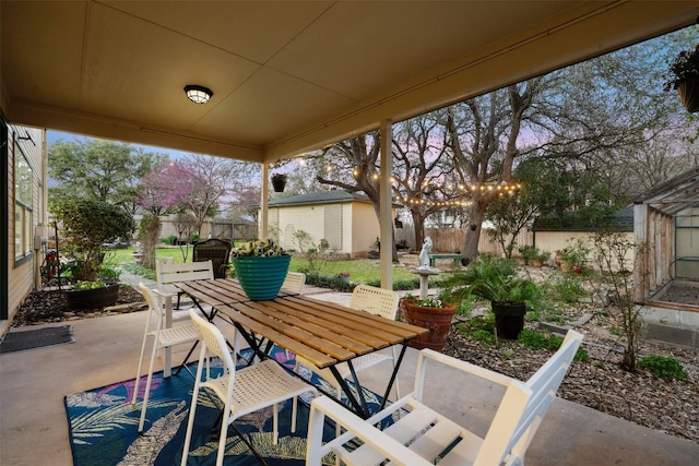 view of patio featuring a fenced backyard, an outbuilding, and outdoor dining space