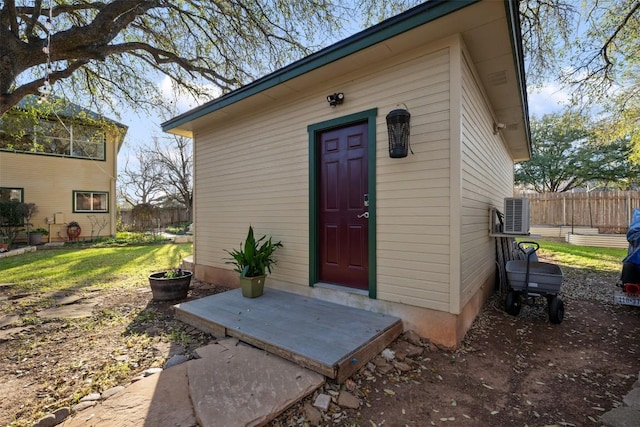 view of outdoor structure featuring cooling unit, entry steps, and fence