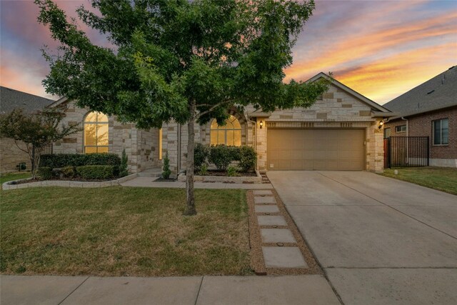 obstructed view of property featuring stone siding, concrete driveway, a garage, and a lawn