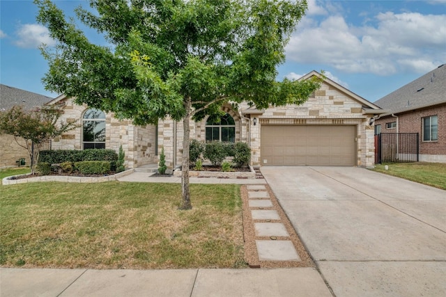 view of property hidden behind natural elements with a front lawn, fence, a garage, stone siding, and driveway