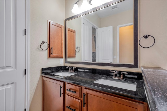 full bath with double vanity, visible vents, and a sink