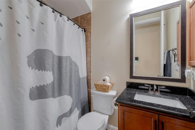 bathroom with toilet, curtained shower, vanity, and a textured wall