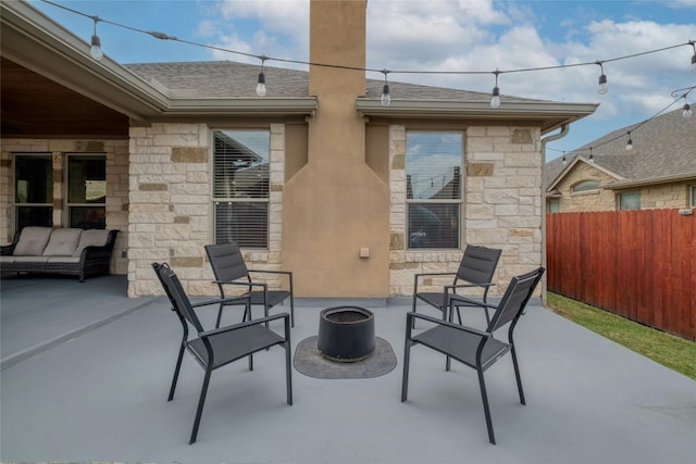 view of patio featuring a fire pit and fence