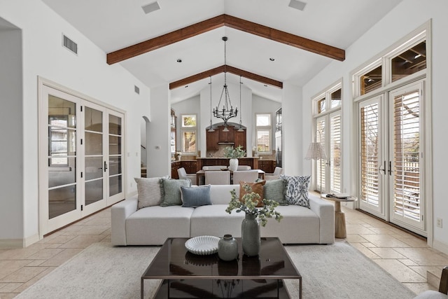 living area with visible vents, stone tile floors, french doors, and beamed ceiling