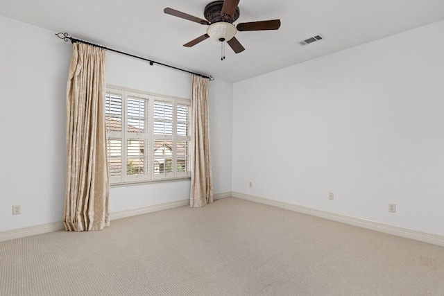 carpeted spare room featuring visible vents, baseboards, and ceiling fan