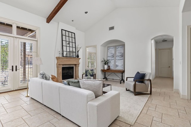 9100 Calera Dr Unit 10, Austin, TX 78735 - living area featuring high vaulted ceiling, a fireplace, stone tile floors, arched walkways, and french doors