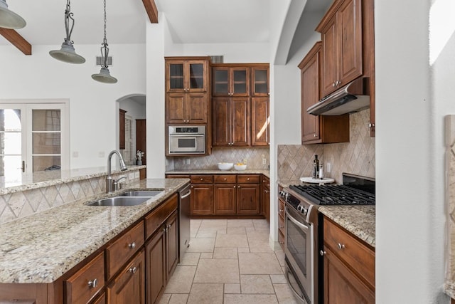 9100 Calera Dr Unit 10, Austin, TX 78735 - kitchen featuring stainless steel appliances, under cabinet range hood, beam ceiling, decorative backsplash, and arched walkways