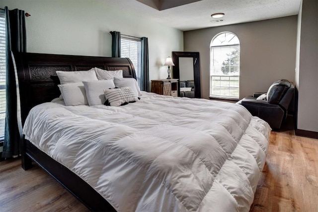 bedroom with wood finished floors and a textured ceiling