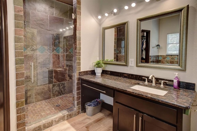 full bath with wood finished floors, a stall shower, and vanity