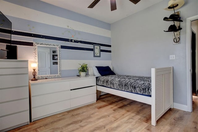 bedroom featuring baseboards, light wood-type flooring, and ceiling fan