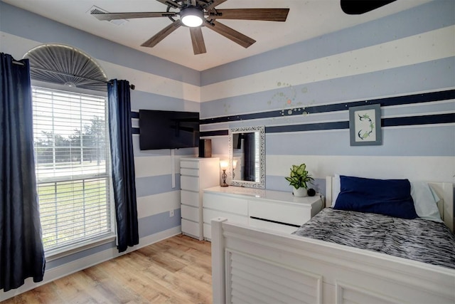 bedroom with baseboards, light wood-style floors, and a ceiling fan