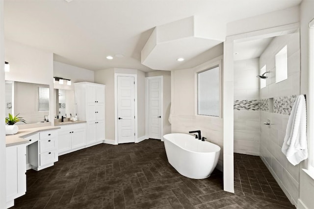 bathroom featuring vanity, a freestanding tub, recessed lighting, and a walk in shower