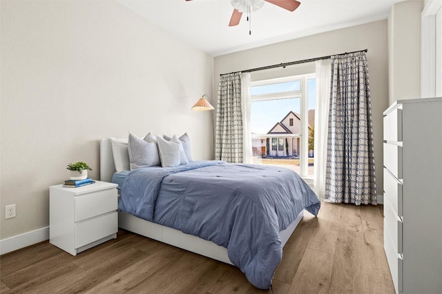 bedroom featuring wood finished floors, baseboards, and a ceiling fan