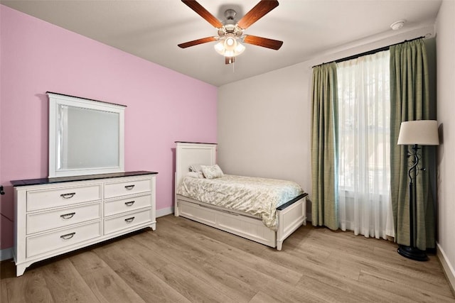 bedroom featuring light wood finished floors, baseboards, and ceiling fan