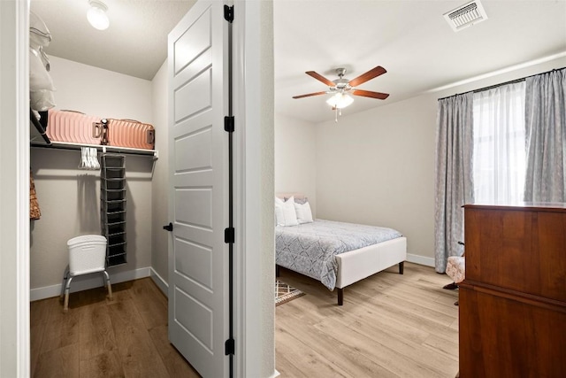 bedroom with wood finished floors, baseboards, and ceiling fan