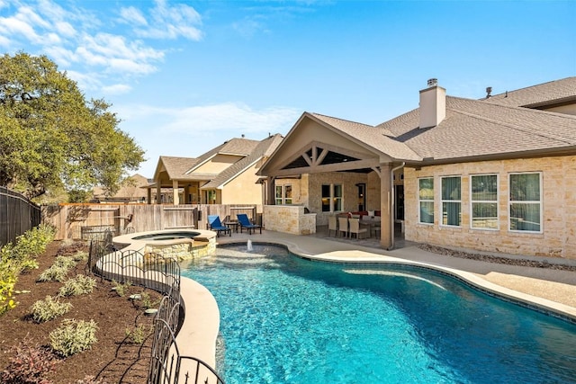 view of swimming pool with a pool with connected hot tub, a fenced backyard, and a patio area