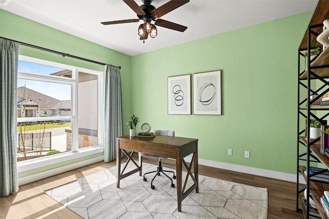 office space with light wood finished floors, baseboards, and ceiling fan