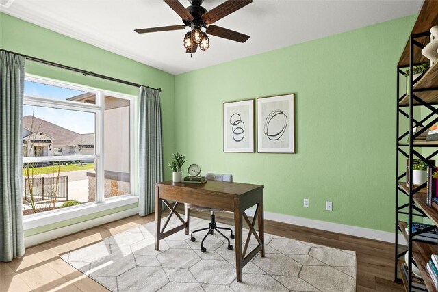 office space with ceiling fan, light wood-type flooring, and baseboards