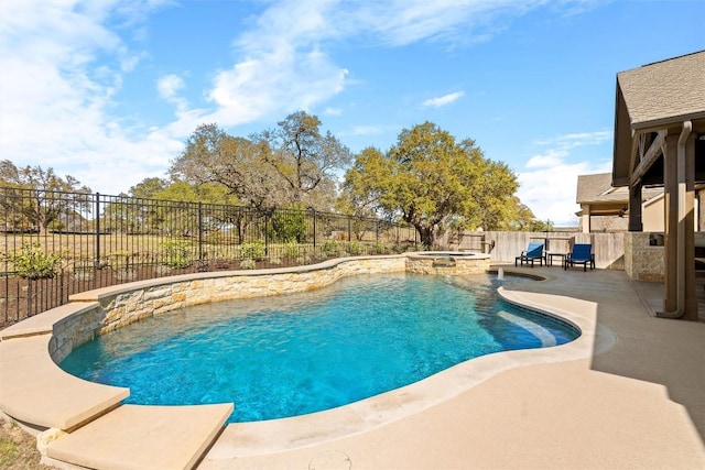 view of pool featuring a patio area, an outdoor kitchen, a pool with connected hot tub, and a fenced backyard