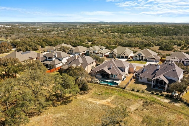 aerial perspective of suburban area with a pool and a heavily wooded area
