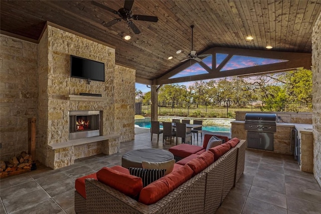view of patio with a ceiling fan, grilling area, area for grilling, a fenced backyard, and an outdoor living space with a fireplace