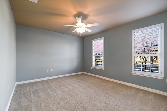 carpeted spare room with baseboards and ceiling fan