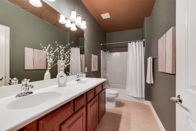 bathroom featuring tile patterned flooring, visible vents, double vanity, and a sink