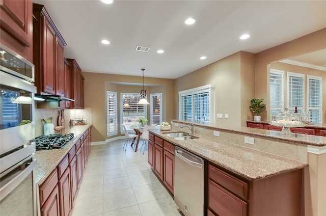 kitchen with a center island with sink, visible vents, a sink, decorative backsplash, and stainless steel appliances