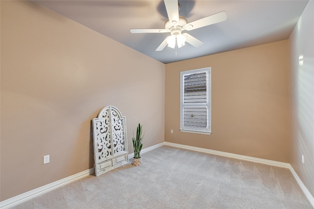 carpeted empty room featuring baseboards and ceiling fan