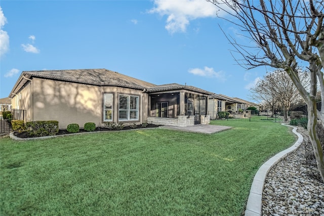 back of house with stucco siding, a fenced backyard, a yard, a sunroom, and a patio area