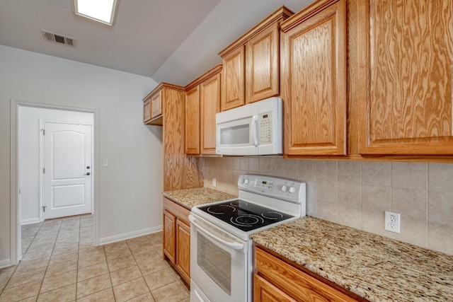 kitchen featuring white appliances, light stone counters, light tile patterned floors, visible vents, and tasteful backsplash