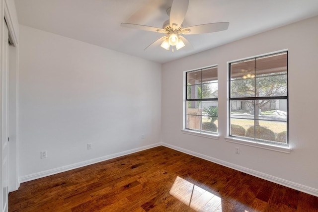 unfurnished room with baseboards, wood finished floors, and a ceiling fan