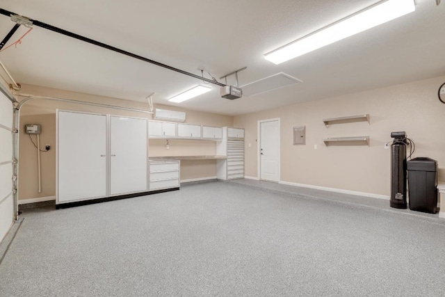 garage featuring electric panel, a garage door opener, and baseboards