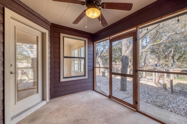 unfurnished sunroom with a ceiling fan