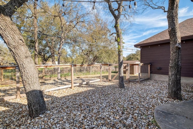 view of yard featuring an outbuilding and fence