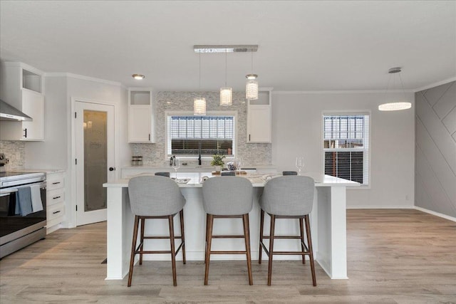 kitchen featuring a breakfast bar area, light wood-type flooring, light countertops, stainless steel electric range, and white cabinets