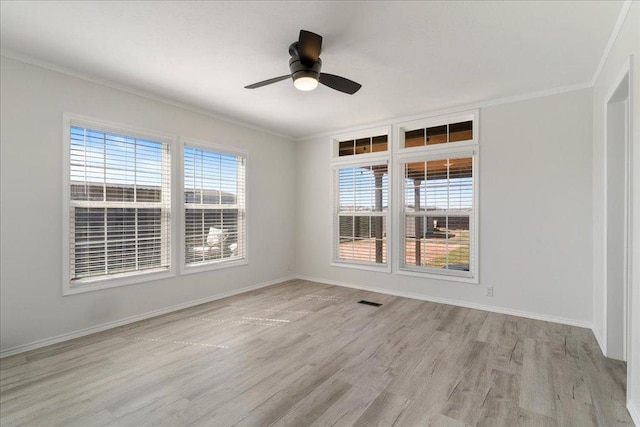 empty room featuring a healthy amount of sunlight, light wood-style floors, and baseboards