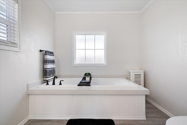 bathroom with crown molding, a bath, and baseboards