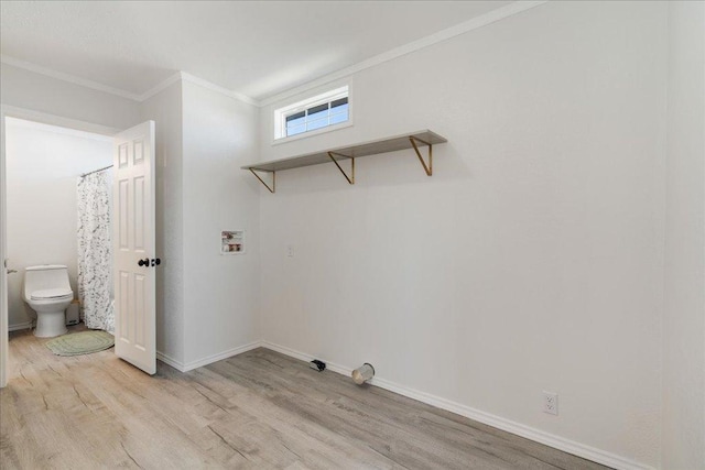 laundry area with baseboards, light wood finished floors, laundry area, washer hookup, and crown molding