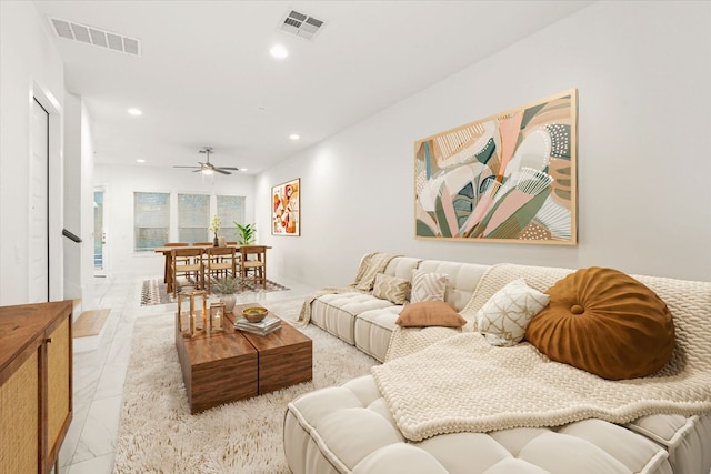 living area featuring visible vents, recessed lighting, and marble finish floor