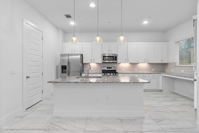 kitchen with marble finish floor, a sink, stainless steel appliances, decorative backsplash, and light stone countertops