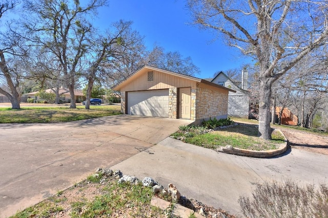 view of front of home featuring an outbuilding, stone siding, and driveway