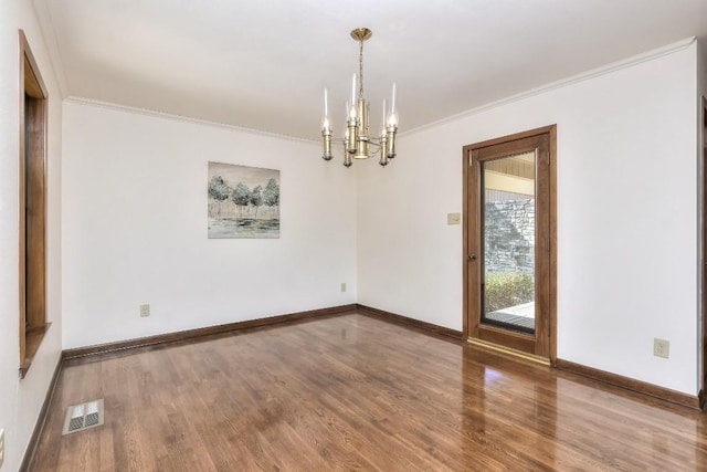 unfurnished room featuring wood finished floors, baseboards, visible vents, ornamental molding, and a chandelier