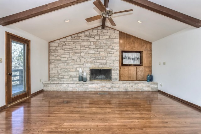 unfurnished living room with lofted ceiling with beams, wood finished floors, a fireplace, and ceiling fan